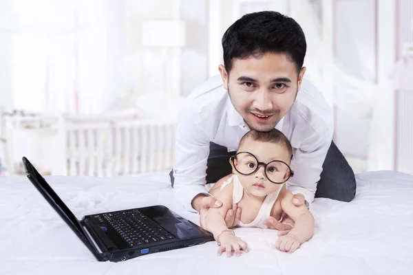 Cute infant wearing round glasses on bed — Stock Photo, Image