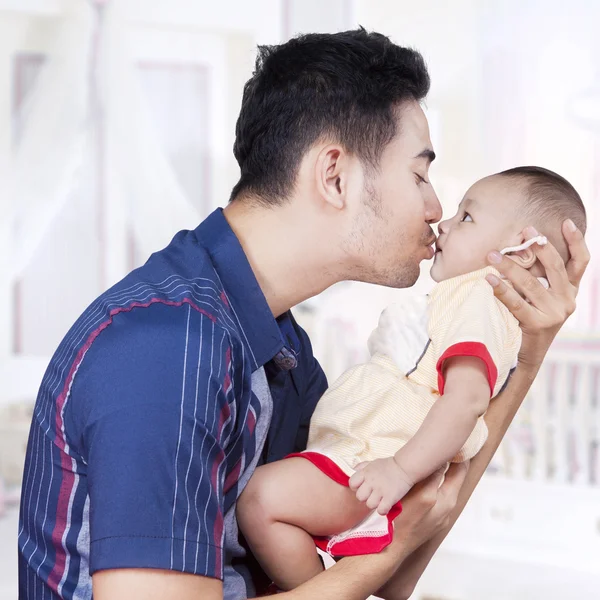 Dad holds and kiss his baby — Stock Photo, Image