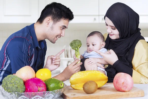 Papa bietet seinem Baby Brokkoli an — Stockfoto