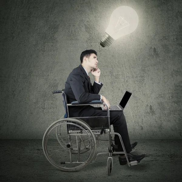 Travailleur handicapé assis sous une lampe lumineuse — Photo