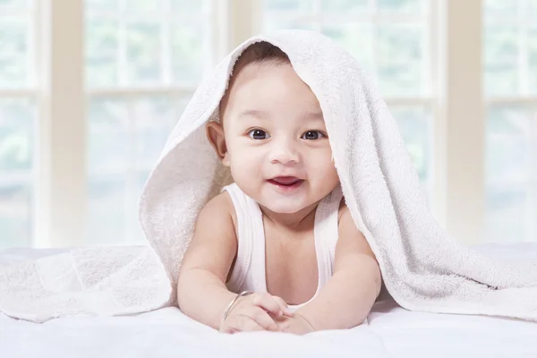 Aufgeregter kleiner Junge unter Handtuch im Bett — Stockfoto