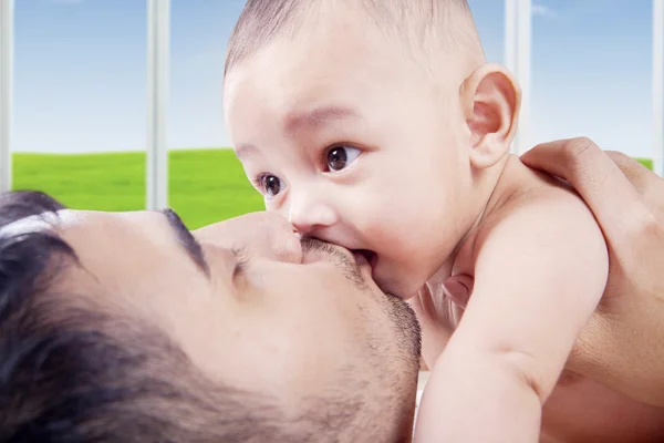 Baba sevgisini onun bebeği öperek gösterilen — Stok fotoğraf