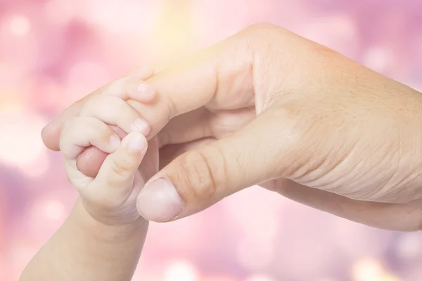 Hand van baby en vader met bokeh achtergrond — Stockfoto