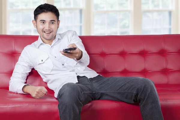 Man use cellphone to change tv channel — Stock Photo, Image