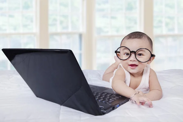 Small baby boy on bed with laptop — 图库照片