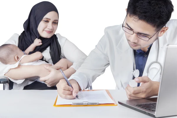 Jovem médico escrever prescrição para o bebê — Fotografia de Stock