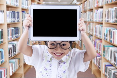 Beautiful child with tablet in the library