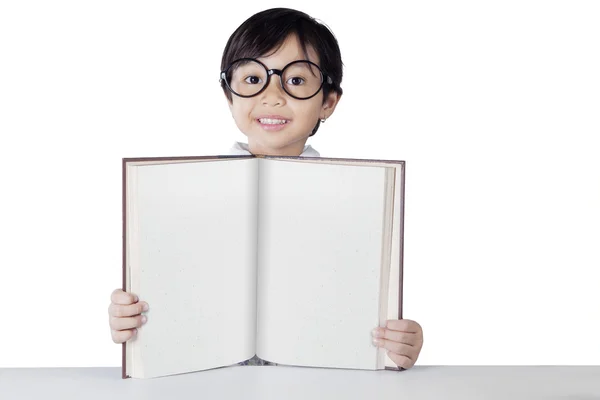 Attractive little student shows empty book — Stockfoto