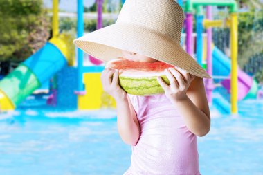 Child enjoy watermelon at pool