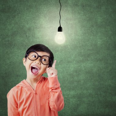 Cheerful attractive child pointing at lamp