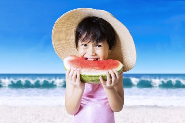 Cute girl with hat eating watermelon