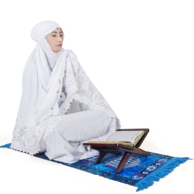 Muslim woman praying with Koran