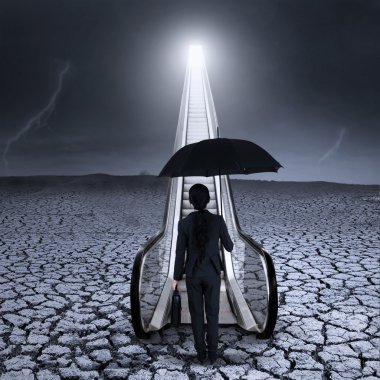 Young businesswoman standing at the escalator