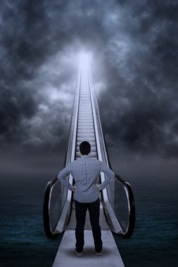 Young man standing by an escalator