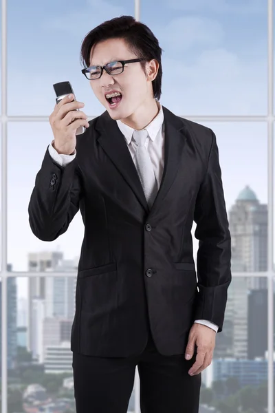 Empreendedor irritado gritando em seu telefone — Fotografia de Stock