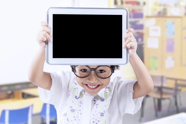 Adorable niño pequeño mostrando tableta en la escuela —  Fotos de Stock