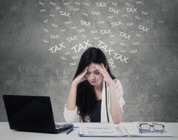 Confused woman counting her tax — Stockfoto