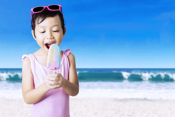 Excited girl eats ice cream at shore — Stok fotoğraf