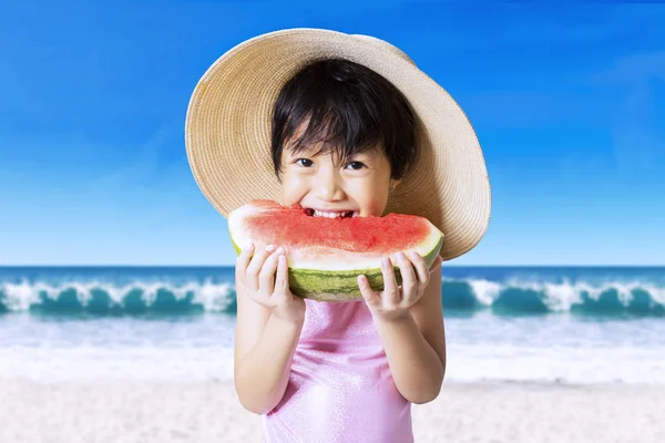 Cute girl with hat eating watermelon