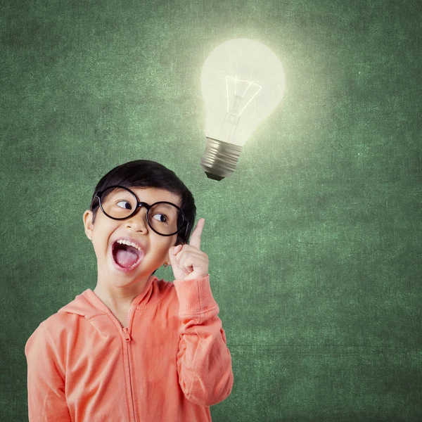 Funny little girl and bright light bulb — Stock Photo, Image