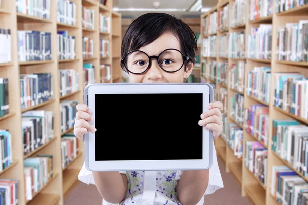 Little girl with tablet in library alley — Stockfoto