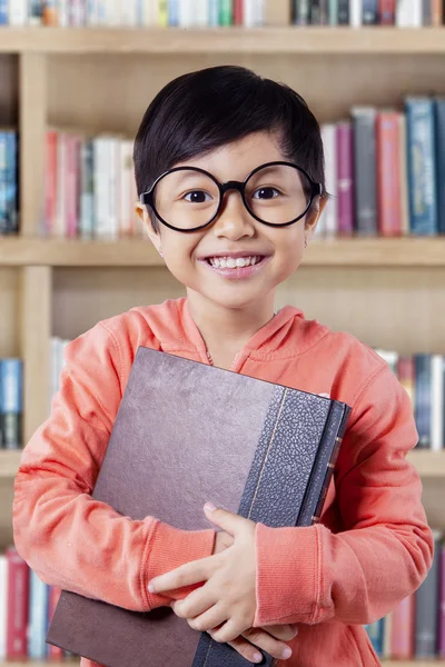 Gioiosa bambina con libro sorridente sulla macchina fotografica — Foto Stock