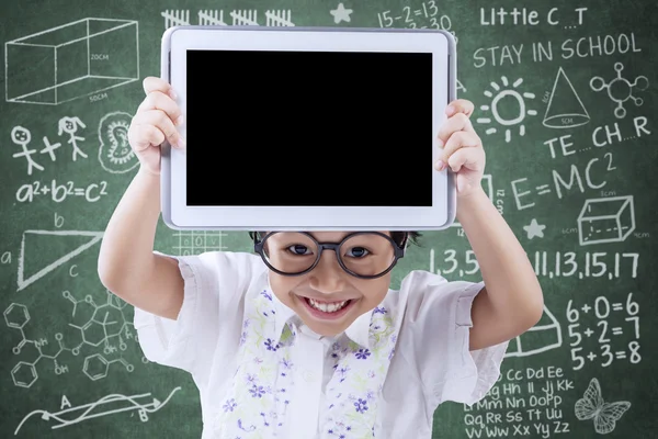 Fröhliches kleines Mädchen zeigt Tablet im Unterricht — Stockfoto