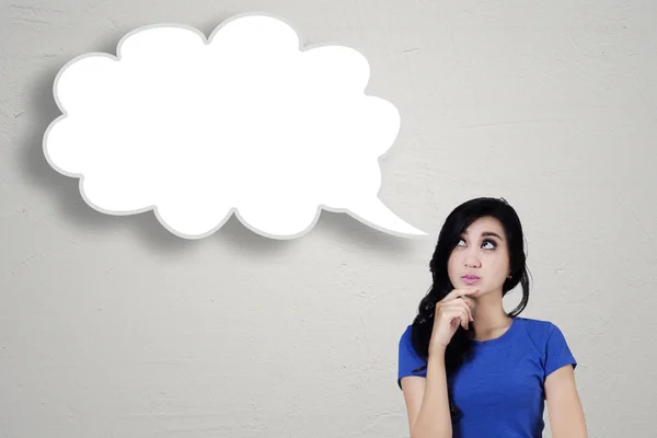 Pretty woman looking up at cloud speech — Stockfoto