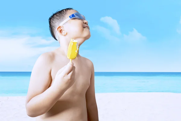 Sweet child holds ice cream at seaside — Stockfoto