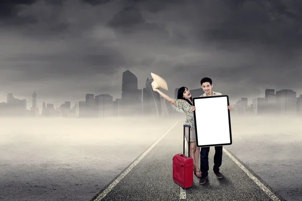 Two tourists holding billboard outdoors — Stock Photo, Image