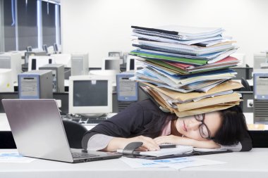 Depressed female worker napping on desk