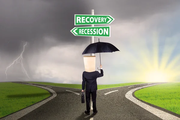 Imprenditore con cartello alla ripresa o alla recessione finanziaria — Foto Stock