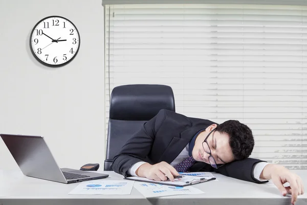 Exhausted caucasian worker sleeping in office — Stockfoto