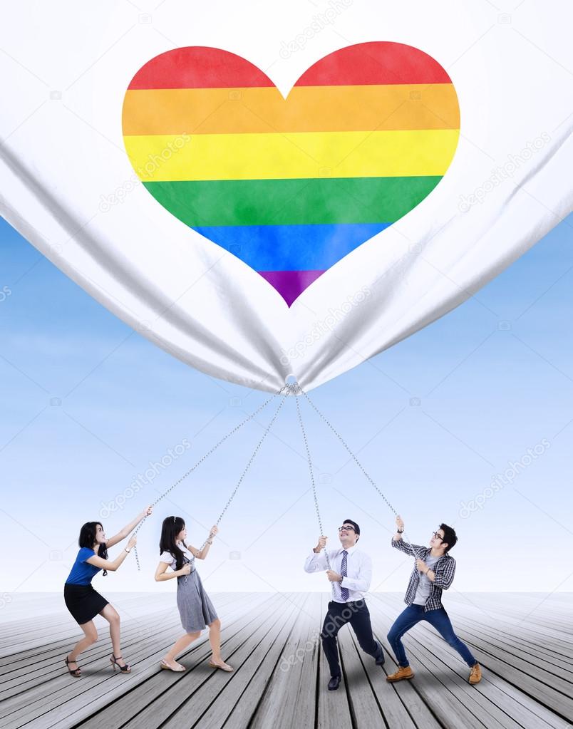 People pulling banner with colorful heart
