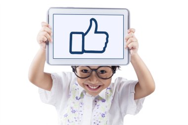 Child with tablet showing a thumb up sign