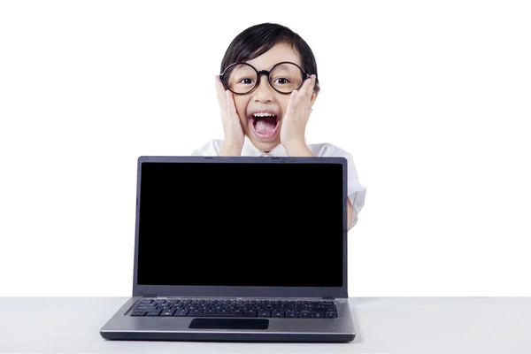 Cheerful kid screaming with laptop on the table — Stock fotografie