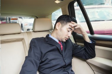 Depressed man sitting inside car at traffic jam