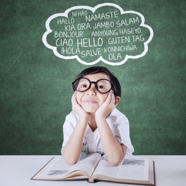 Pensive kid studying multi language with textbook