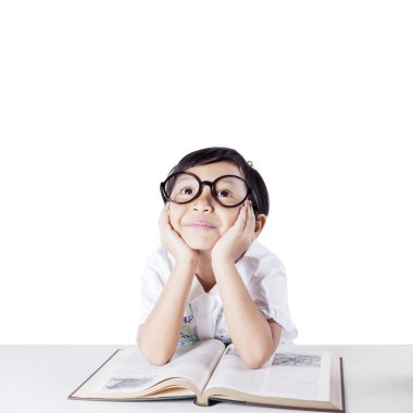 Student daydreaming while studying with book