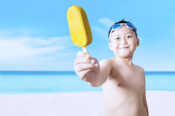 Male kid offering ice cream at beach — 스톡 사진