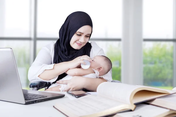 Ibu memberi makan bayi saat bekerja — Stok Foto