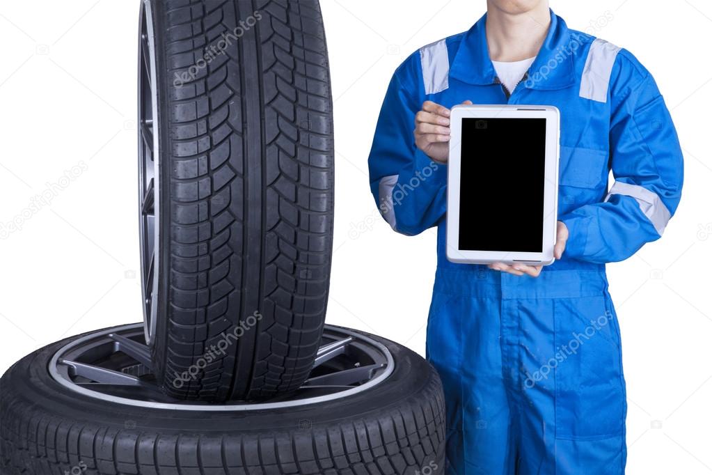 Mechanic showing tablet screen near tires