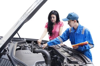 Mechanic checking the car machine with the owner