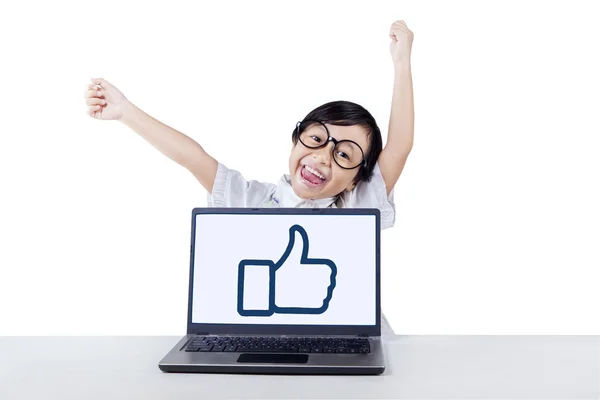 Bambino attraente con pollice su segno sul computer portatile — Foto Stock