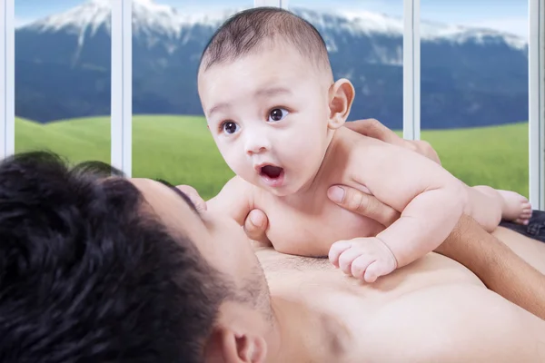 Attractive infant lying over father chest — Stock Photo, Image