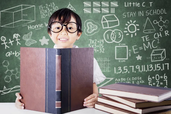 Estudante da escola primária bonito ler livros em sala de aula — Fotografia de Stock