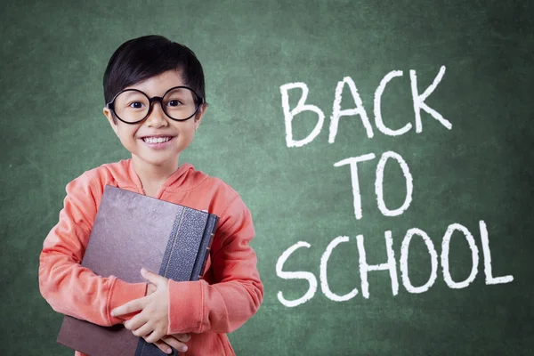 Pequeño estudiante inteligente y de vuelta al texto escolar — Foto de Stock