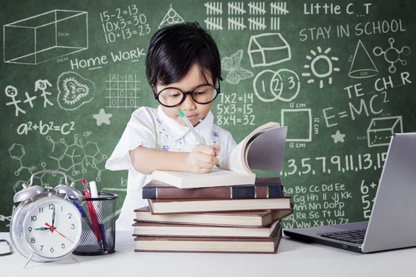 Student studying in class with clock and laptop — Stok fotoğraf