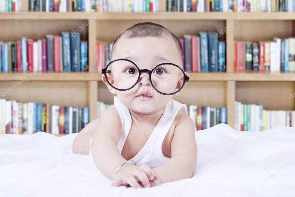 Sweet baby with glasses and a bookcase background