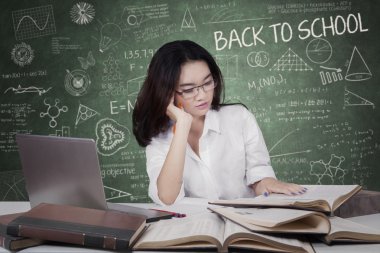 High school student reads books in class